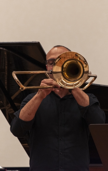 Vemos o trombonista José Milton Vieira e parte do piano atrás dele.