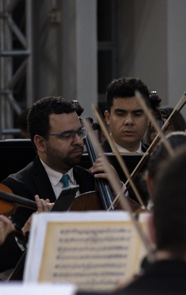 Vemos vários músicos da OSPA tocando instrumentos de cordas, como violinos e violoncelos.