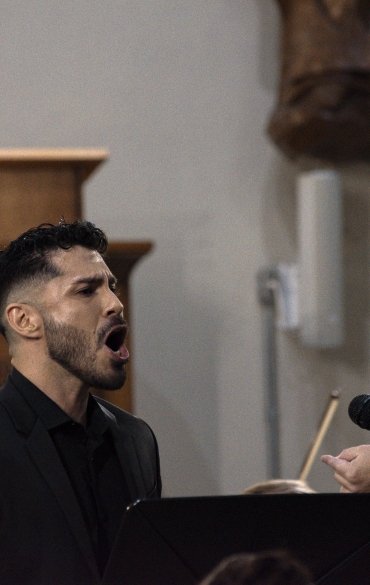 Vemos o solista Matías Herrera cantando e o maestro Evandro Matté regendo.