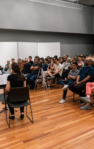 Na imagem aparece o público do recital, além dos músicos.